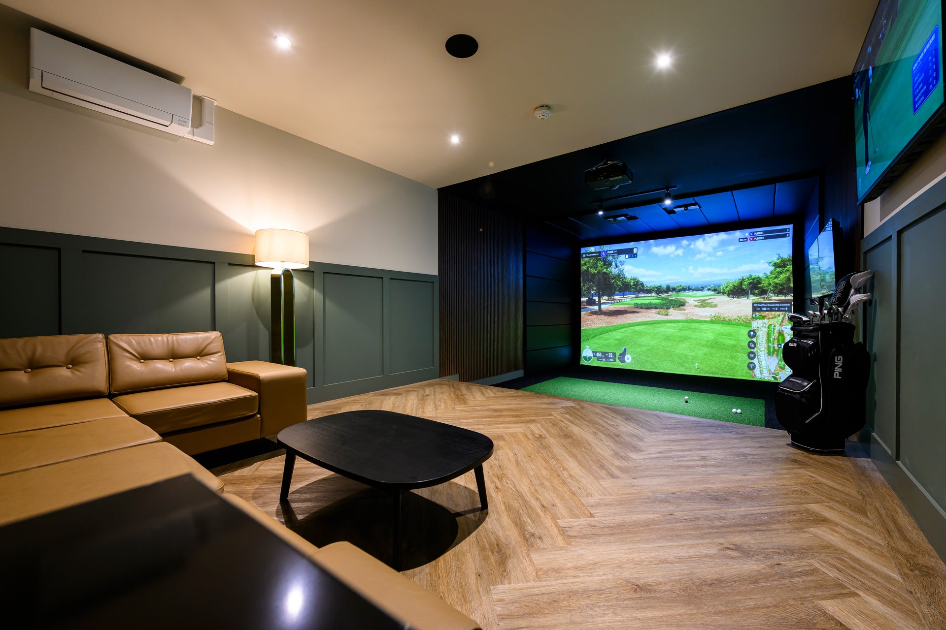 Modern home entertainment room with a large screen displaying a golf game.